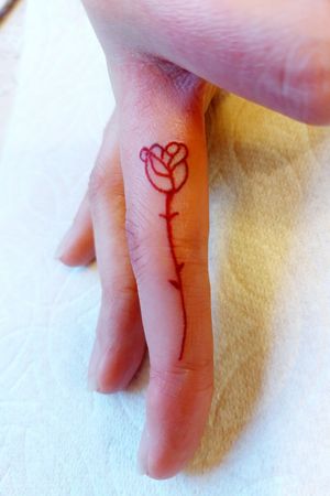 Red lined rose on a finger