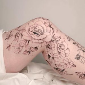Elegant and detailed peony flower tattoo on upper leg in Los Angeles, showcasing fine line and illustrative style.