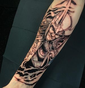 A striking blackwork tattoo featuring an armored warrior with helmet on forearm. By Jethro Wood.