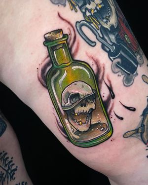 Vibrant neo-traditional upper leg tattoo featuring a skull and bottle motif, expertly done by tattoo artist Jethro Wood.