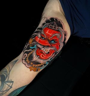 Captivating illustrative design by Jethro Wood, featuring a traditional Japanese hannya mask adorned with a delicate necklace on the upper arm.