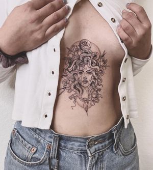 Polina's blackwork illustrative design featuring a mesmerizing snake, medusa, and woman motif on the stomach.