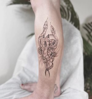 Unique lower leg tattoo by Polina featuring a intricate design of a snake and hand in blackwork, dotwork, and fine line style.