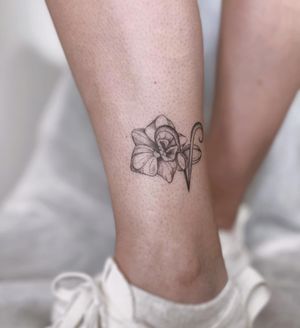 Elegantly detailed flower tattoo by Polina, perfect for your lower leg. The fine line work and illustrative style will make this tattoo a true work of art.