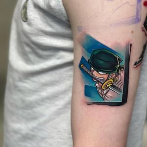 Experience a bold new-school blackwork tattoo of Zoro wielding a sword on your upper arm by the talented artist, Artemis.