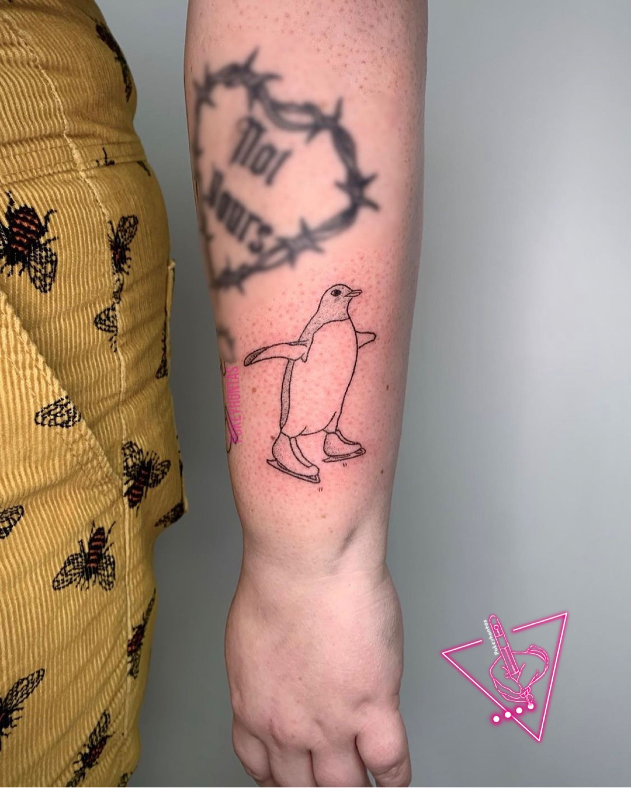 Continuous line penguin tattoo on the inner forearm