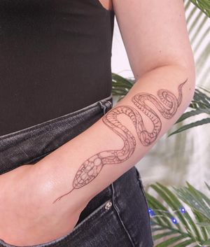 A beautifully intricate snake tattoo on the forearm, featuring fine line work and illustrative style by the talented artist Polina.