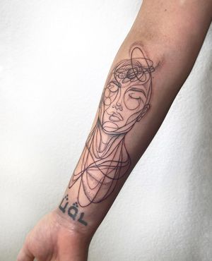 Polina's skillfully executed forearm tattoo features a intricate patterned design of a man in a fine line illustrative style.