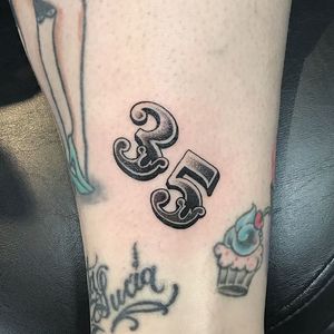 Unique blackwork number design with illustrative lettering by Jose Cordova on the arm.