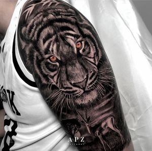 Experience the power of nature with this stunning blackwork and realism tattoo featuring a majestic deer and fierce tiger in Los Angeles.