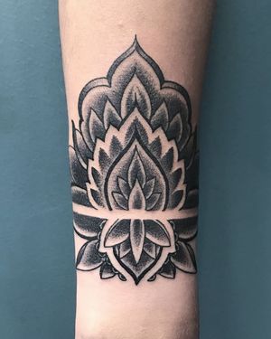 A stunning blackwork forearm tattoo featuring a intricate lotus, stunning pattern, and beautiful mandala design by talented artist Jose Cordova.