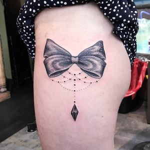 Experience elegant blackwork and illustrative style with this bow tie tattoo by Jose Cordova on your upper leg.