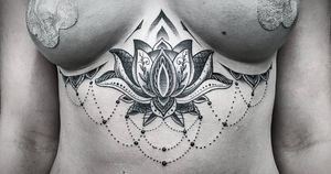 Detailed blackwork mandala with dotwork accents, created by Jose Cordova for an elegant and unique under_boob tattoo design.