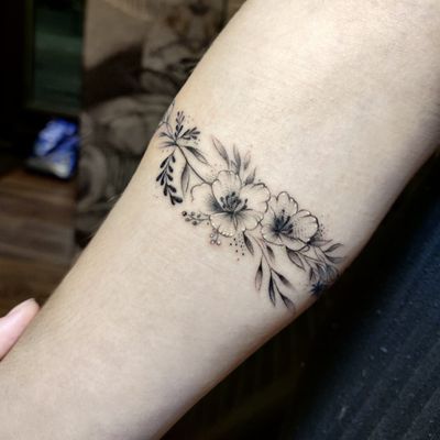 Elegant flower design on forearm, expertly executed by tattoo artist Mary Shalla in a delicate fine line style.