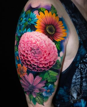 Experience the beauty of a lifelike flower tattooed on your upper arm by the talented artist Alex Santo.