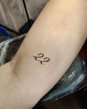 Get a sleek and stylish number tattoo on your arm with small lettering design by talented artist Mary Shalla.