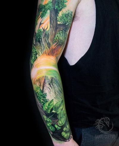 Experience nature's beauty with this stunning sleeve tattoo featuring a detailed tree and blooming flower, created by the talented artist Alex Santo.