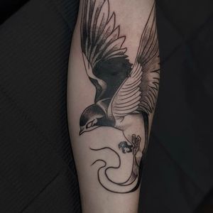 Black and gray bird tattoo with intricate wings by Luca Salzano for a striking forearm piece.