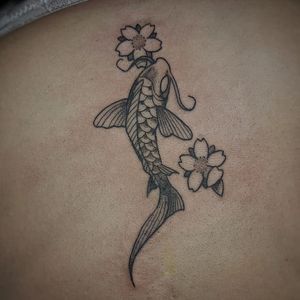 Elegant upper back tattoo by Luca Salzano featuring intricate fine line details of fish, koi, and flowers.