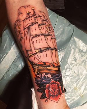 Impressive neo-traditional forearm tattoo featuring a beautiful flower and ship design by Frankie Brown.