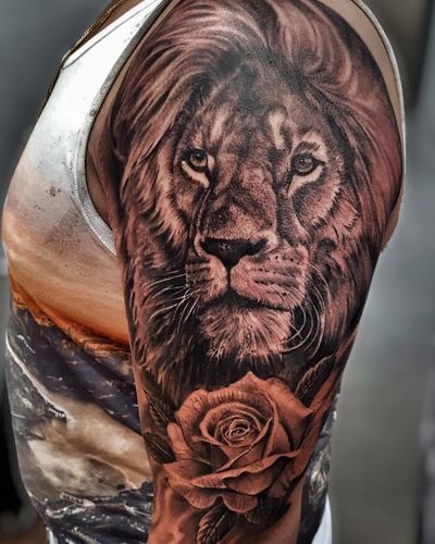 Get mesmerized by this black and gray masterpiece featuring a majestic lion and delicate flower, skillfully executed by Mauro Imperatori.