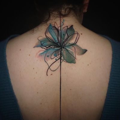 Captivating upper back tattoo by Aygul combining delicate flowers and x-ray elements in a stunning watercolor style.