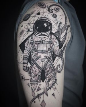 Experience the wonders of space with this unique blackwork tattoo by Aygul. Intricate geometric lines and sketchwork detail create a stunning astronaut design.