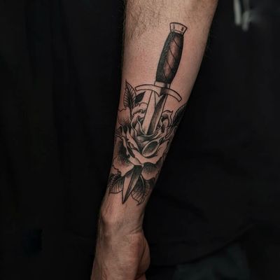 Stunning black and gray tattoo featuring a classic rose and dagger design by Luca Salzano.
