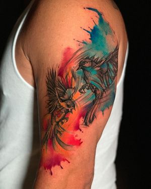 Get a stunning illustrative bird tattoo on your upper arm with vibrant watercolor style by the talented artist Marcel Oliveira.