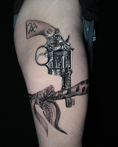 Beautiful black and gray design by Marcel Oliveira, featuring a detailed revolver and bandanna on upper leg.
