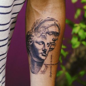 Gabriele Edu's detailed black & gray forearm tattoo features a micro-realistic statue intertwined with illustrative lettering of a powerful quote.