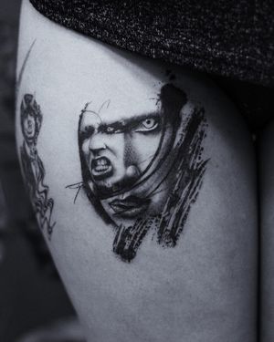 Gabriele Edu brings Marilyn Manson's piercing gaze to life on your upper leg with stunning black and gray realism.
