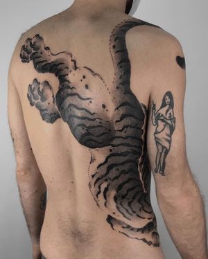 Experience the power and grace of a Japanese tiger in this stunning blackwork and dotwork floral design by FKM TATTOO.