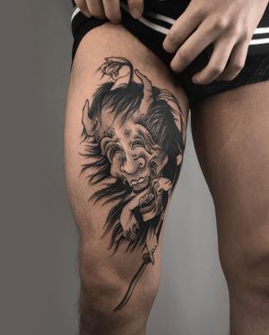 Illustrative blackwork tattoo of a devil with horns holding a sword on the upper leg, by FKM TATTOO