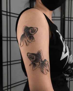 Unique and intricate fish tattoo design by FKM TATTOO, combining dotwork and fine line styles for a stunning look on the upper arm.