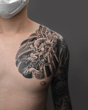 Impressive blackwork illustrative design by FKM TATTOO, showcasing a fierce dragon motif on the shoulder. A true work of art.