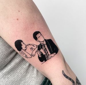 Captivating blackwork tattoo of a man and woman in suits with a glass, designed by Miss Vampira, perfect for the forearm.