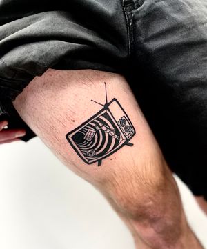 Mesmerizing blackwork TV tattoo on the upper leg, expertly done by Miss Vampira. Perfect for TV enthusiasts!