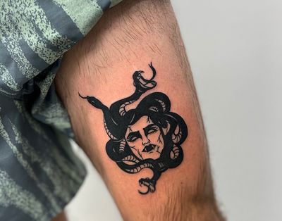 Experience the chilling tale of Medusa's curse in this sinister blackwork tattoo by Miss Vampira on your upper leg.