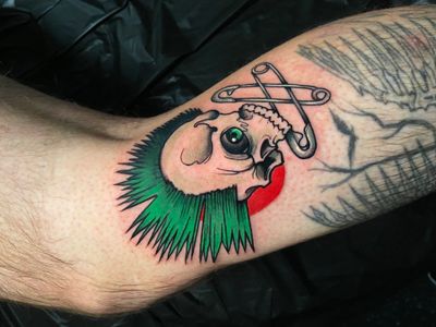 Get edgy with this new school illustrative tattoo of a punk skull with a mohawk on your lower leg by Jethro Wood.
