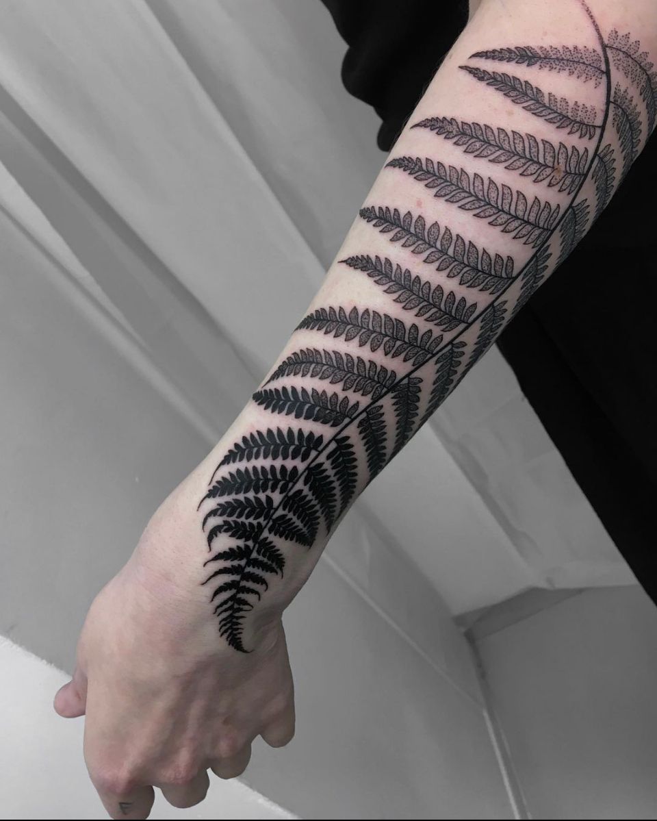 Healed fern leaf tattoo on the left inner forearm.