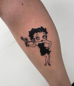 Unique blackwork lower leg tattoo by Miss Vampira featuring a beautiful fusion of flower, woman, and Betty Boop illustrations.