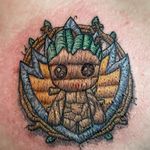 Embroidery style tattoo of baby Groot with the Guardians of the Galaxy badge and branches in the background. Much fun to be had with this style of tattoo. 🖤