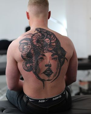 Admire the graceful intertwining of a snake and a woman in this stunning illustrative back piece by Jamie B.