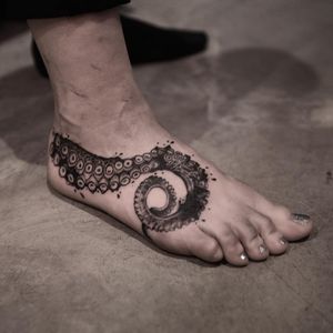 Blackwork design of an octopus created by tattoo artist Jamie B, beautifully placed on the foot.