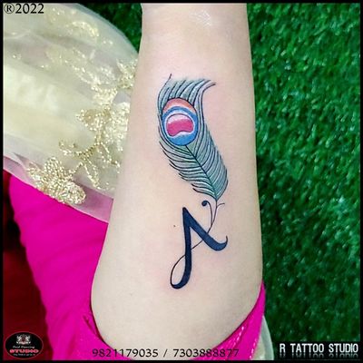 A tattoo calligraphy tattoo Peacock feather tattoo Bansuri tattoo #colourful feather #tattoo #peacock #feather tattoo #Bansuri tattoo Krishna bansuri tattoo #Krishna #feather tattoo #beautiful tattoo feather tattoo