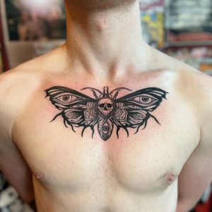 Get a stunning black and gray neo-traditional tattoo featuring a moth and skull design on your chest in London, GB.