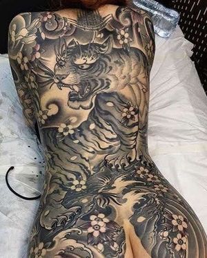 Immerse yourself in the beauty of Kotaro's blackwork masterpiece featuring a fierce tiger and delicate flower on your back.