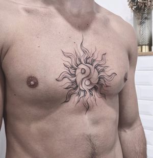 A striking blackwork illustrative sun tattoo on the chest, perfect for those seeking a bold and artistic design in Los Angeles.