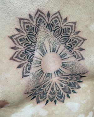 Get a stunning dotwork mandala pattern tattooed on your chest by the talented artist Lawrence.